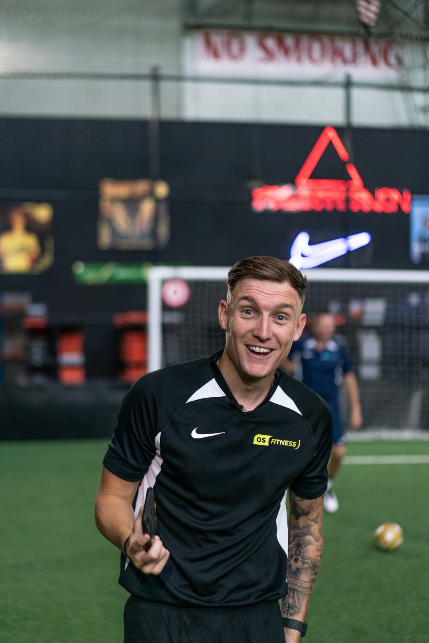 Lee smiling in a dark indoor football arena