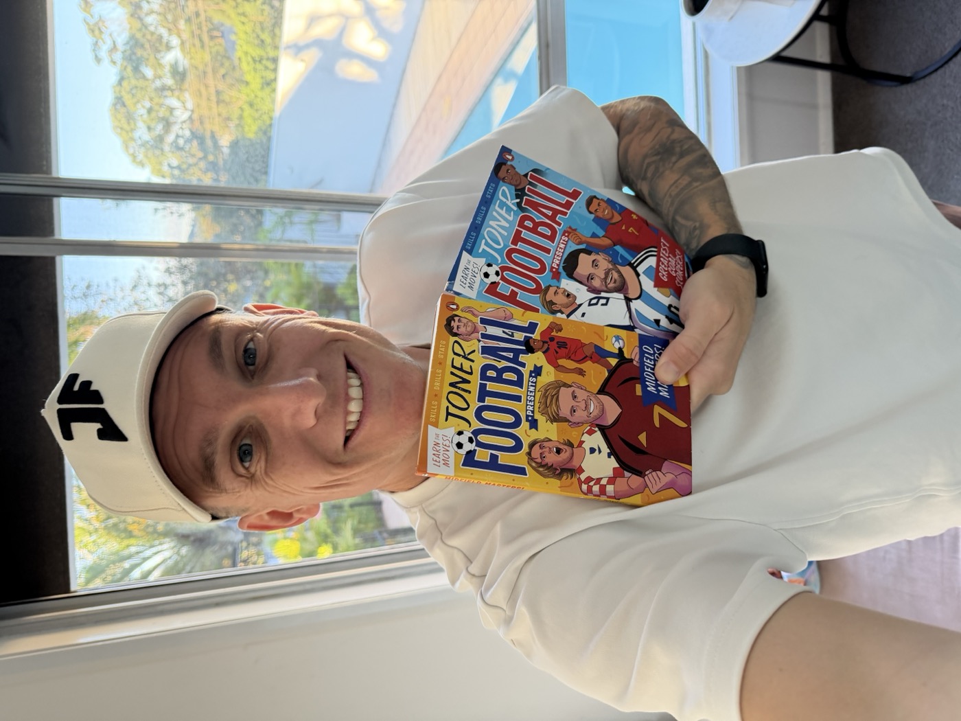 Lee holding two Joner Football books published with Penguin